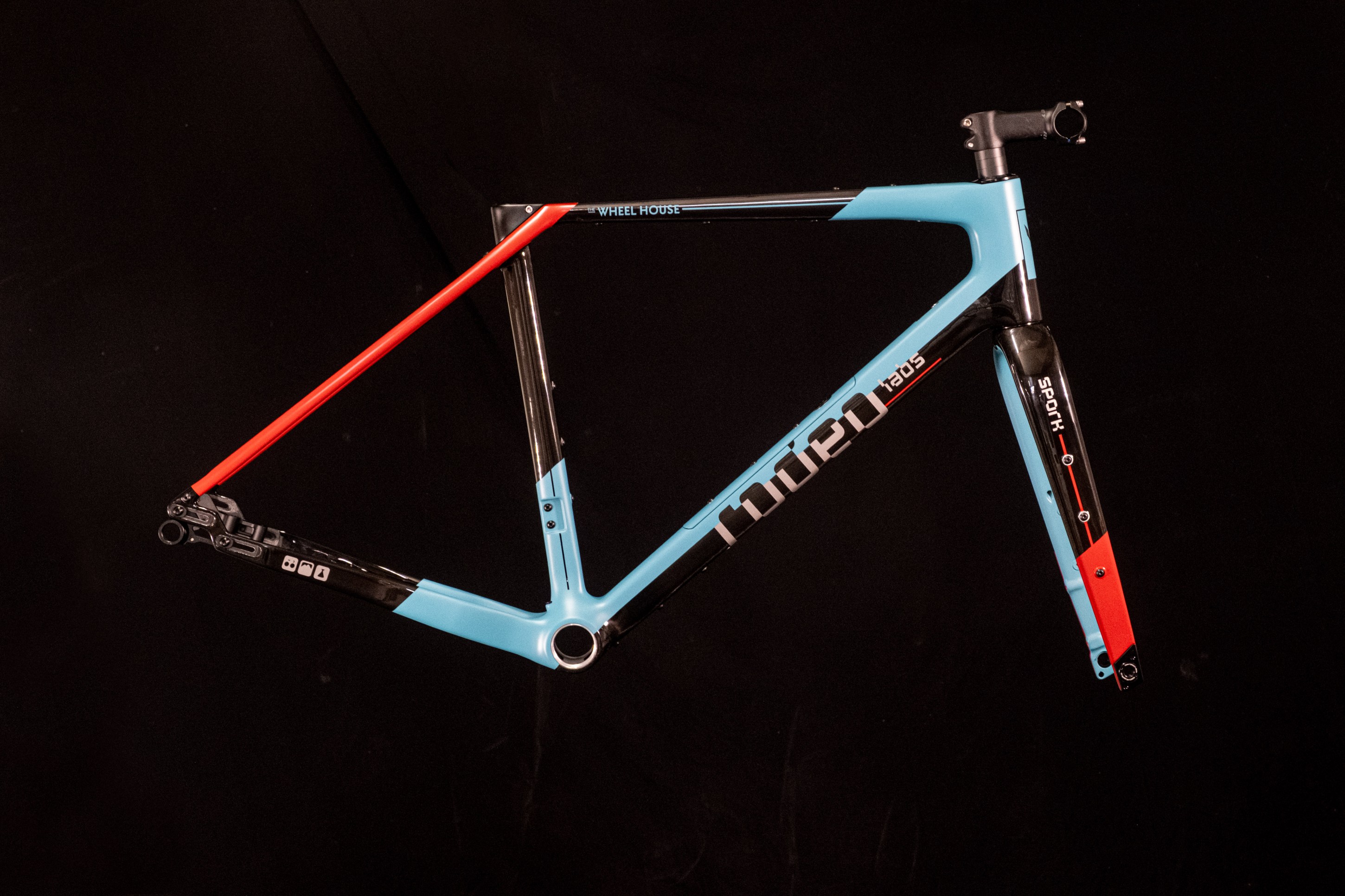 A colorful bicycle frame featuring a blue main body with black and red accents, displayed against a dark background.