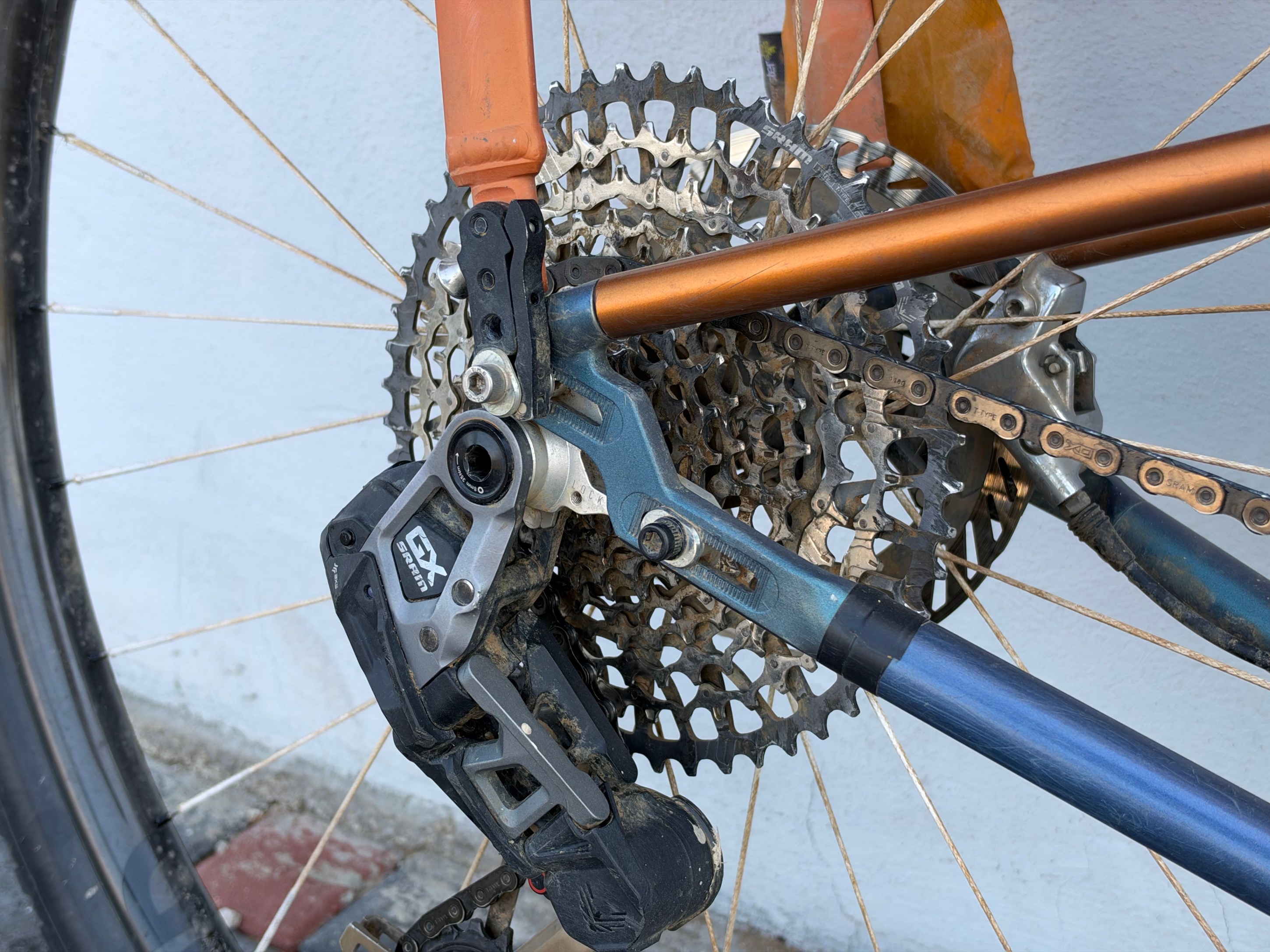Close-up view of a bicycle rear derailleur and cassette, showcasing the gears and chain components.